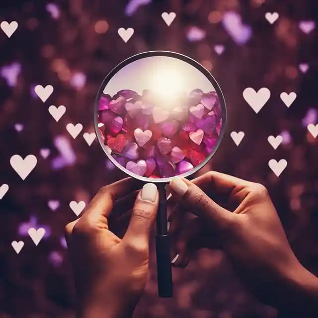 Hands holding a magnifying glass over an Instagram heart