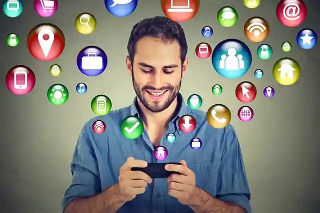 Happy man using texting on smartphone social media application icons