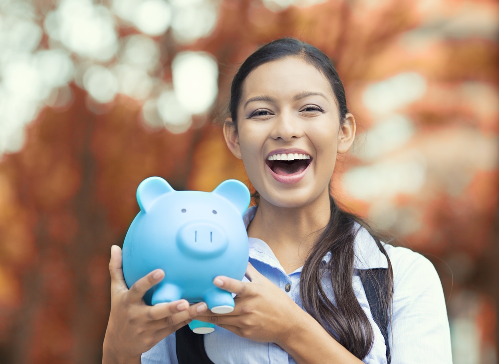PPC costs smiling business woman, bank employee holding piggy bank