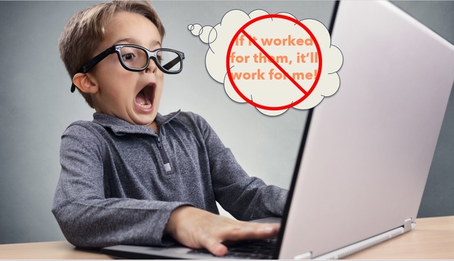 child with eyeglasses in front of a laptop